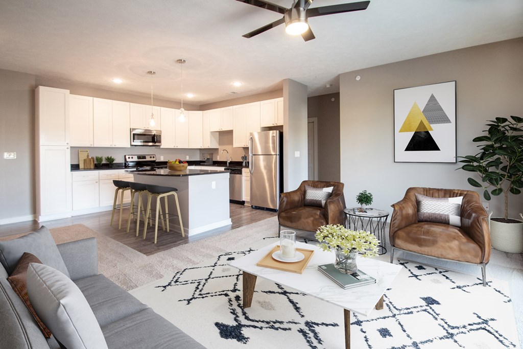 A modern living room with a grey sofa, a coffee table, and a ceiling fan.