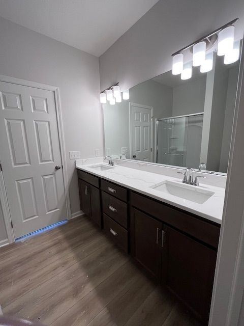 A bathroom with a white sink and brown cabinets.
