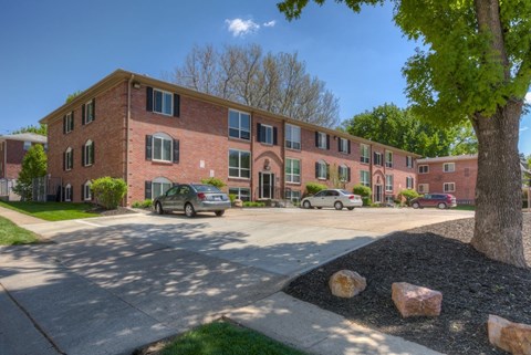 A large red brick building with a tree in front of it.