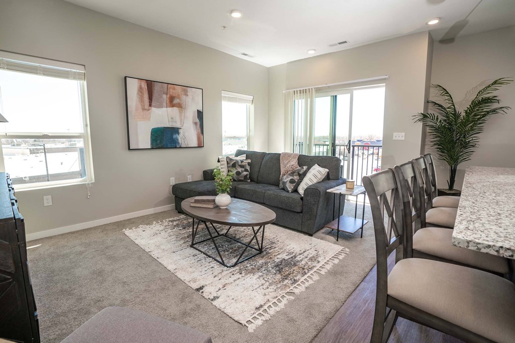 A living room with a grey couch, a coffee table, and a painting on the wall.