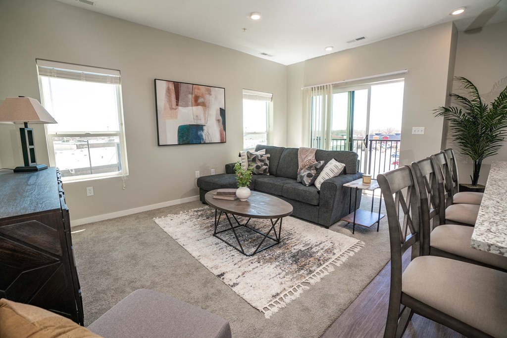 A living room with a grey couch, a coffee table, and a rug with the word "Portland" on it.
