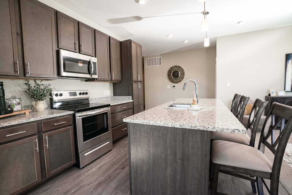 A kitchen with brown cabinets and a granite countertop.