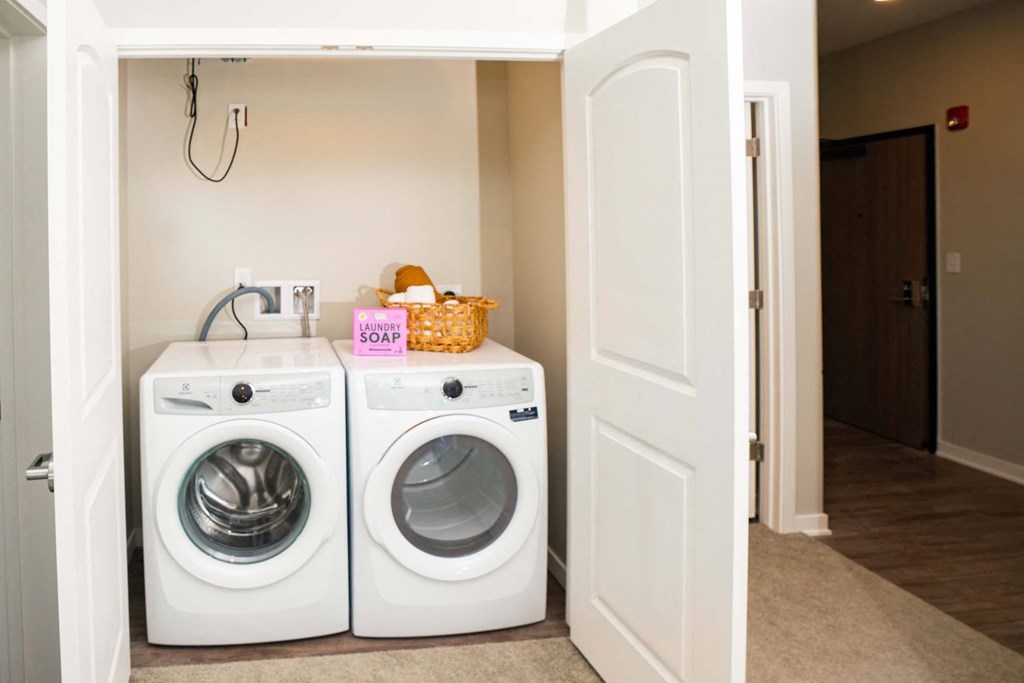 Two white front loading washing machines in a small laundry room.