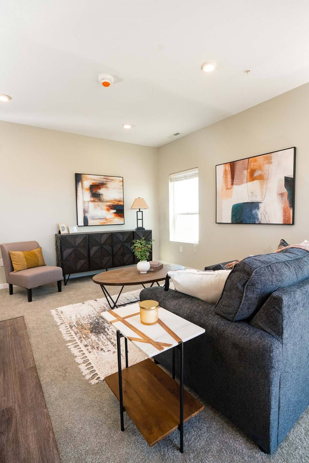 A living room with a grey couch, a brown coffee table, and a rug.