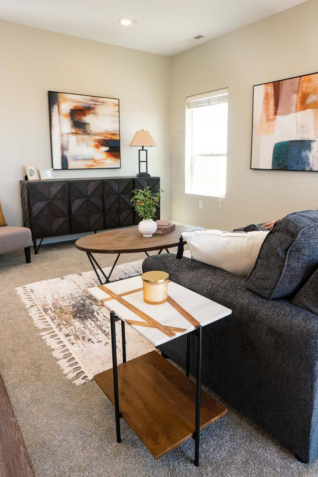 A living room with a grey couch, a coffee table, and a rug.