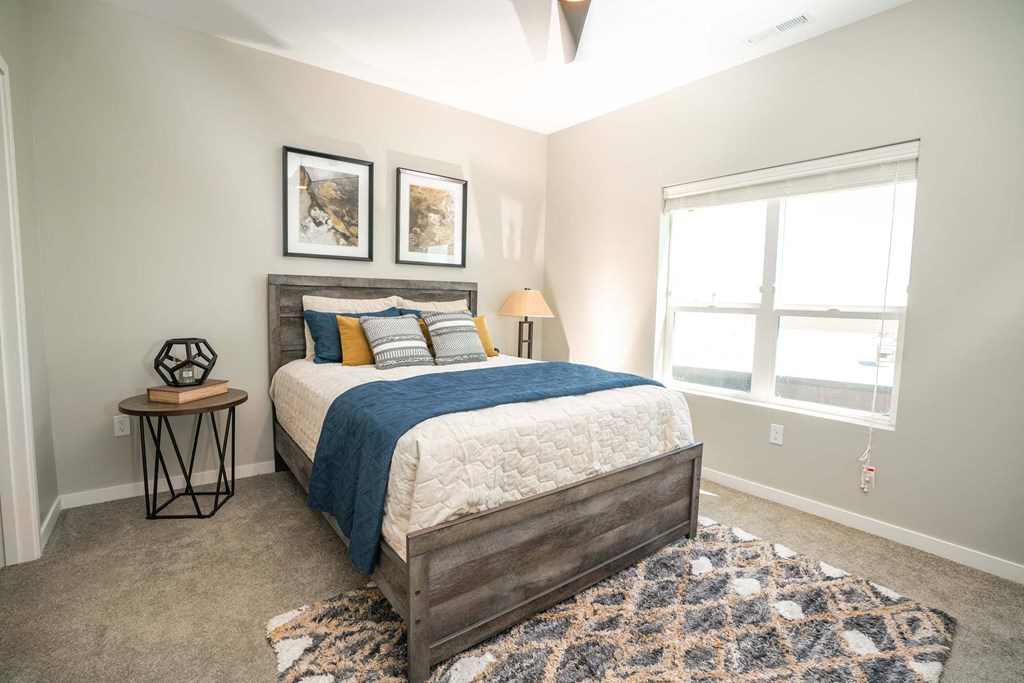 A bedroom with a large bed and a window.