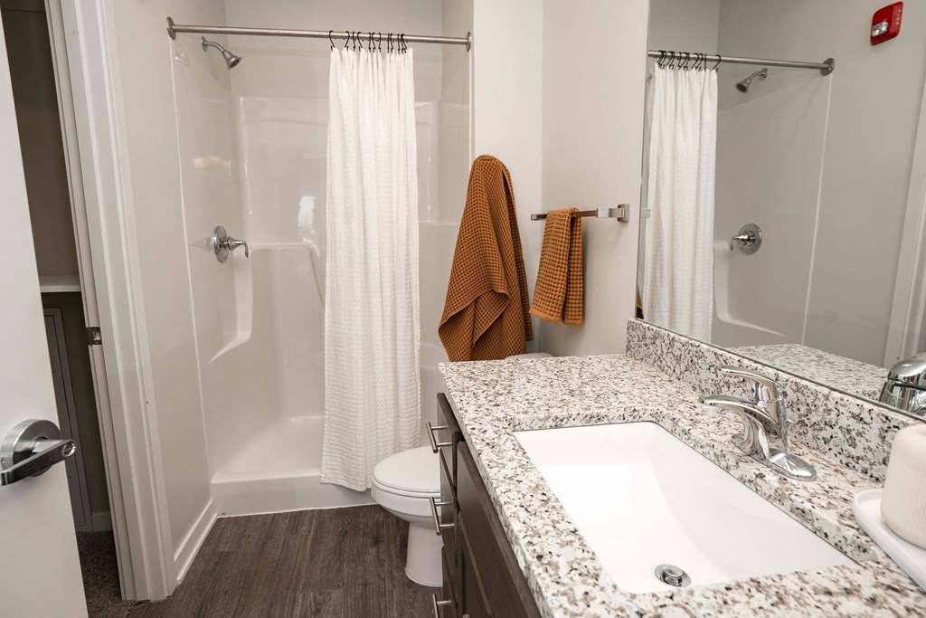 A bathroom with a toilet, sink, and shower.