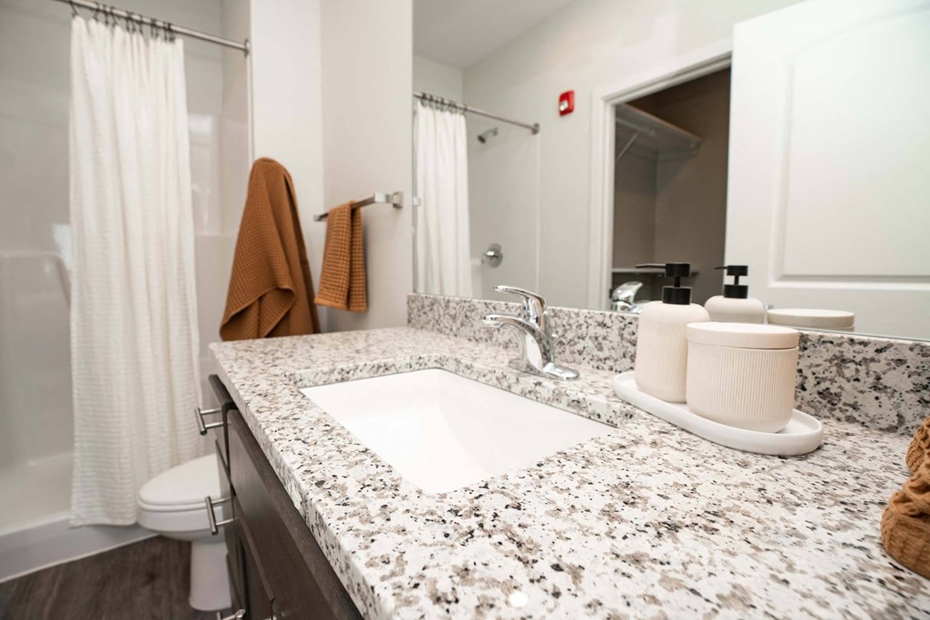 A bathroom with a white sink and a brown towel.