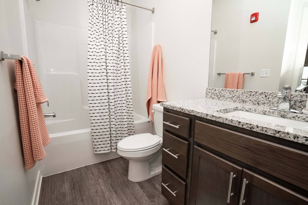 A bathroom with a toilet, sink, and shower curtain.