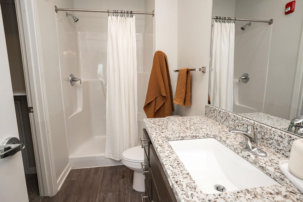 A bathroom with a toilet, sink, and shower.