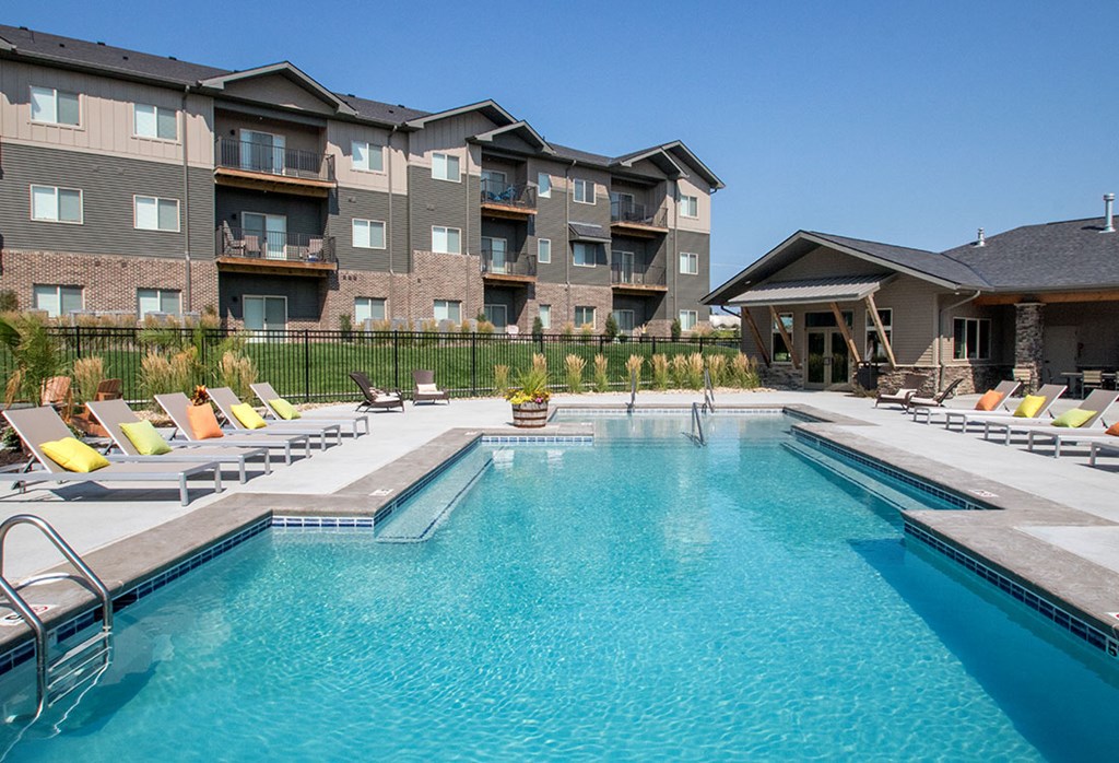 A large swimming pool in front of apartment buildings.