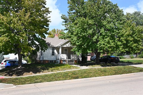 A car is parked on the street in front of a house.