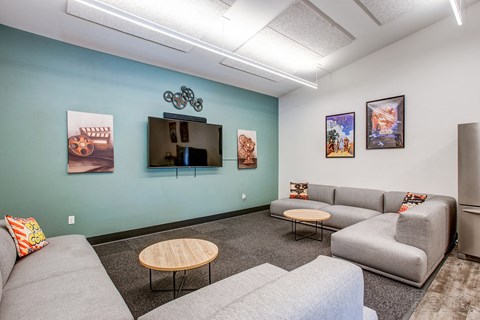 A living room with a grey couch, a wooden table, and a television.