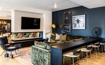 A living room with a large couch and a television on the wall.at Converge KC Uptown, Kansas City, 64111