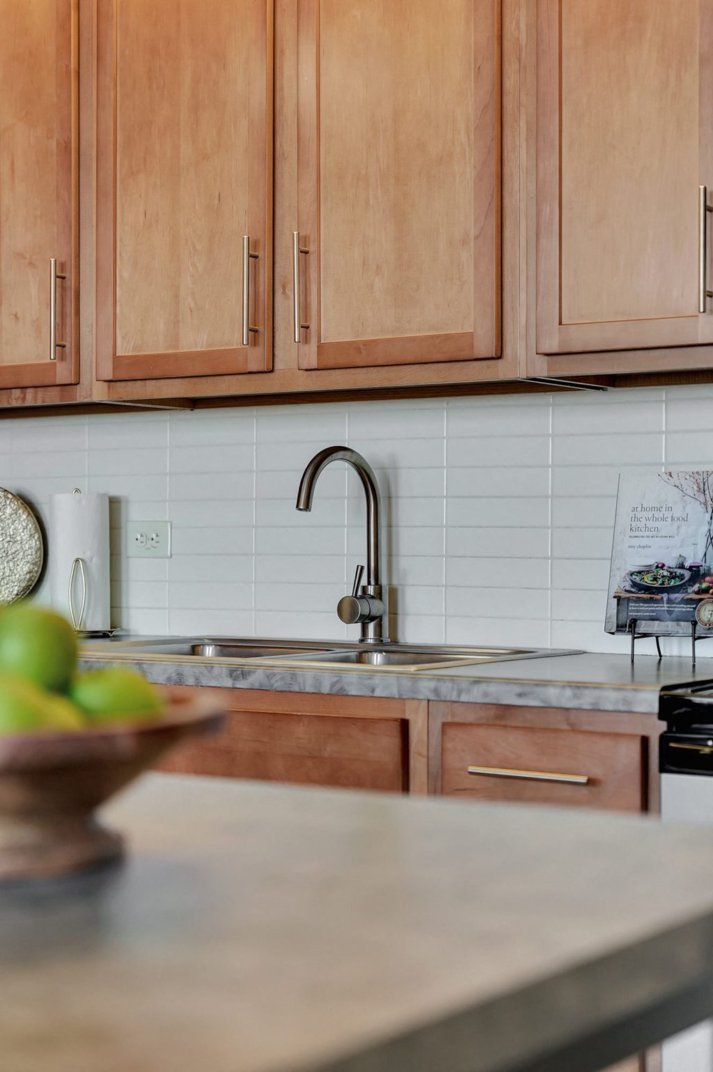 a kitchen with wooden cabinets and a sink at Parkhaus Apartments, Lincoln, NE 68508