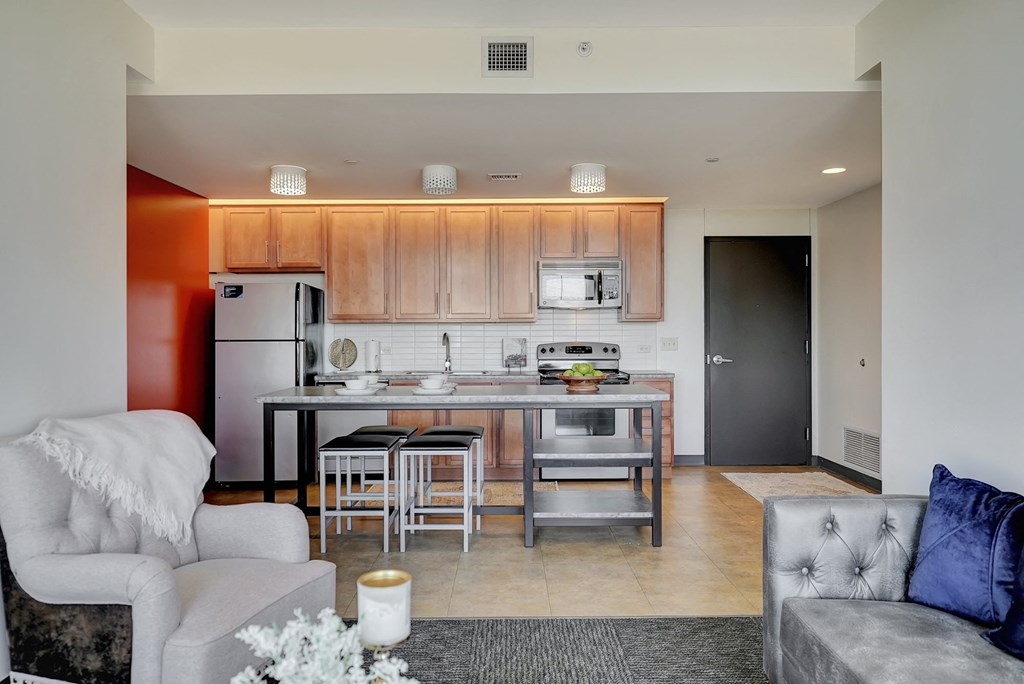 a living room with a kitchen with a island and a couch a living room with a kitchen with a island and a couch at Parkhaus Apartments, Lincoln, NE