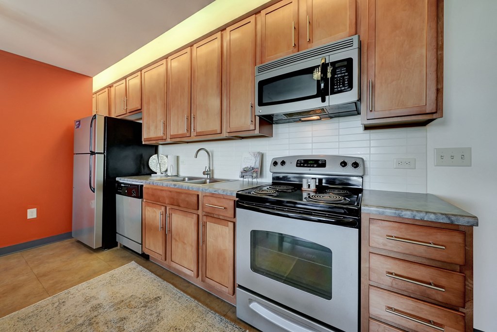 a kitchen with stainless steel appliances and wooden cabinets at Parkhaus Apartments, Lincoln