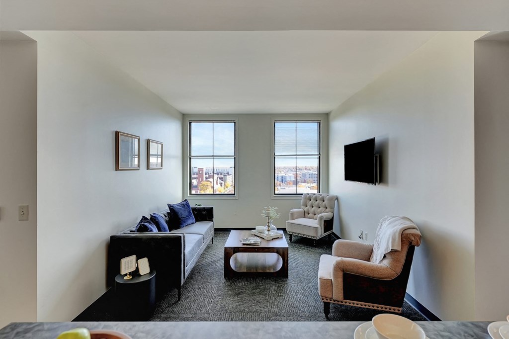 a living room with a couch and two chairs and a tv at Parkhaus Apartments, Lincoln, NE 68508