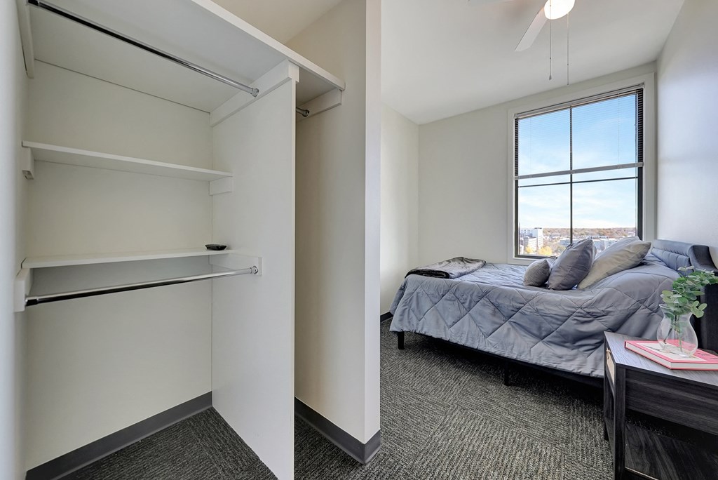 a bedroom with a bed and a closet and a window at Parkhaus Apartments,Nebraska