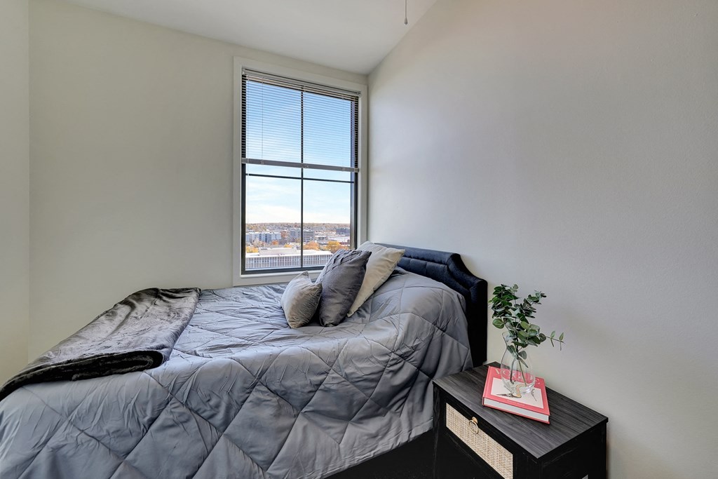an empty bedroom with a bed and a window at Parkhaus Apartments, Lincoln, Nebraska
