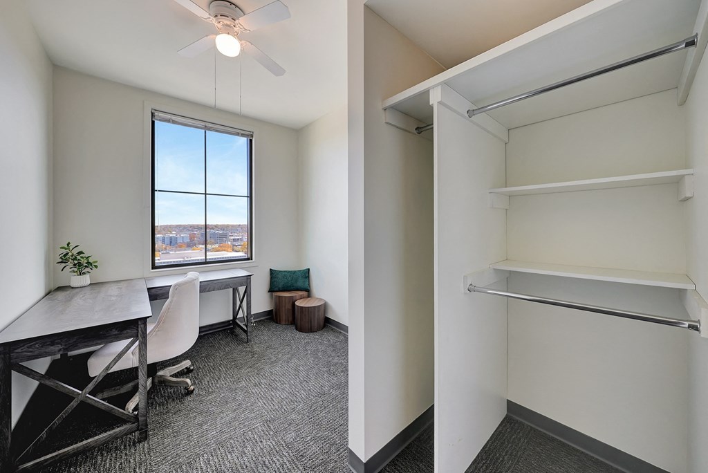 an office with a desk and a window and a closet at Parkhaus Apartments, Lincoln, 68508