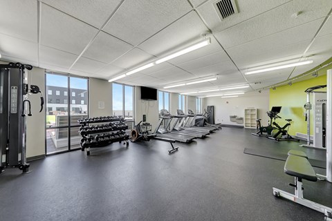 a gym with cardio equipment and weights on the floor at Parkhaus Apartments,Nebraska 68508