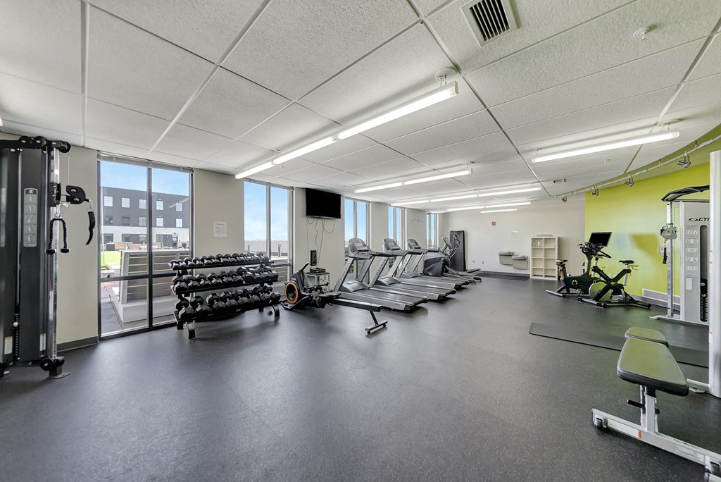 a gym with cardio equipment and weights on the floor a gym with cardio equipment and weights on the floor at Parkhaus Apartments,Nebraska 68508