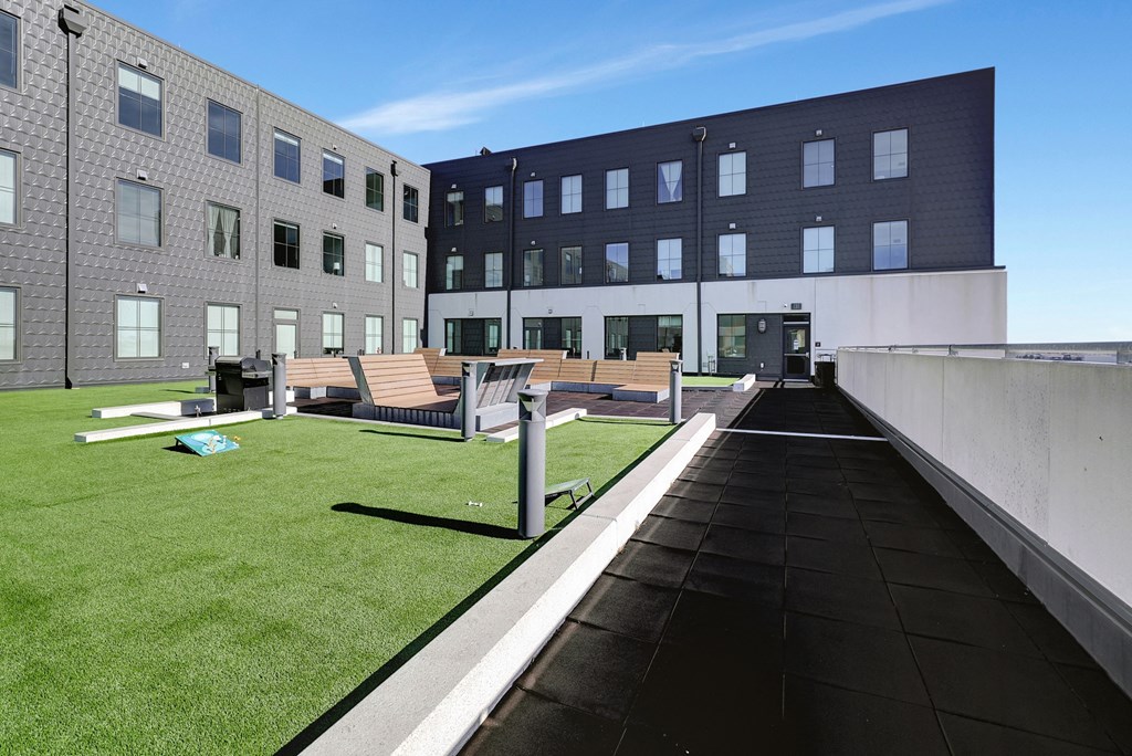 the roof terrace of a building with grass and benches at Parkhaus Apartments, Lincoln, 68508