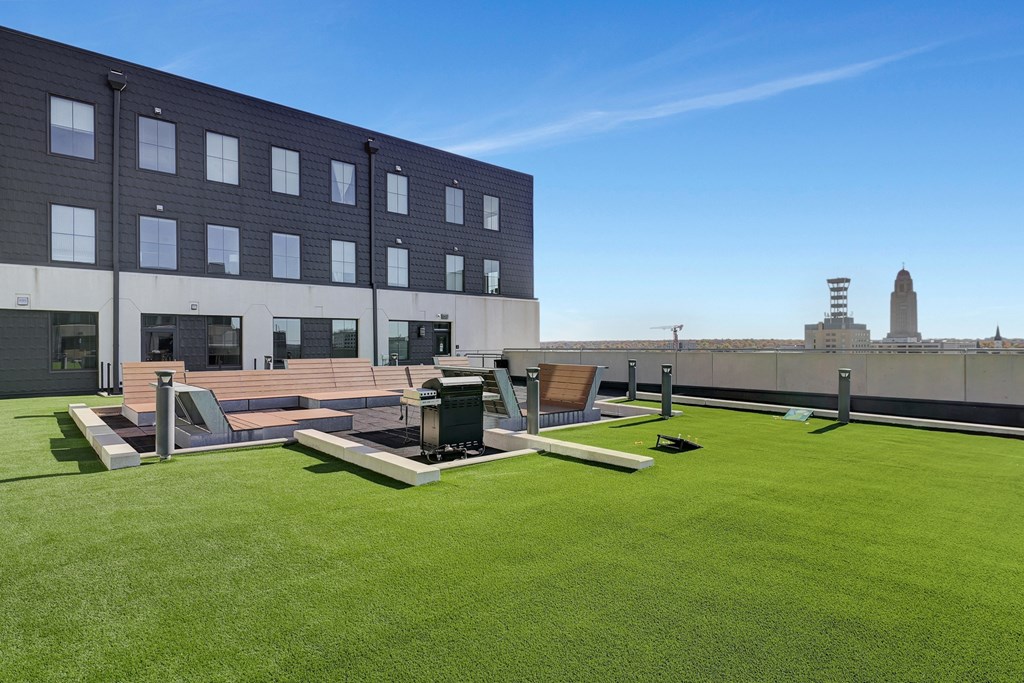 the rooftop patio on the fifth floor of a building with lawn and lounge furniture at Parkhaus Apartments, Lincoln, NE 68508
