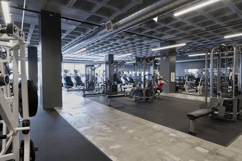 A gym with various exercise equipment and a person working out.at Converge KC Uptown, Kansas City, MO 64111
