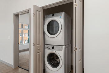 A stack of two washing machines in a cabinet.at Converge KC Uptown, Kansas City