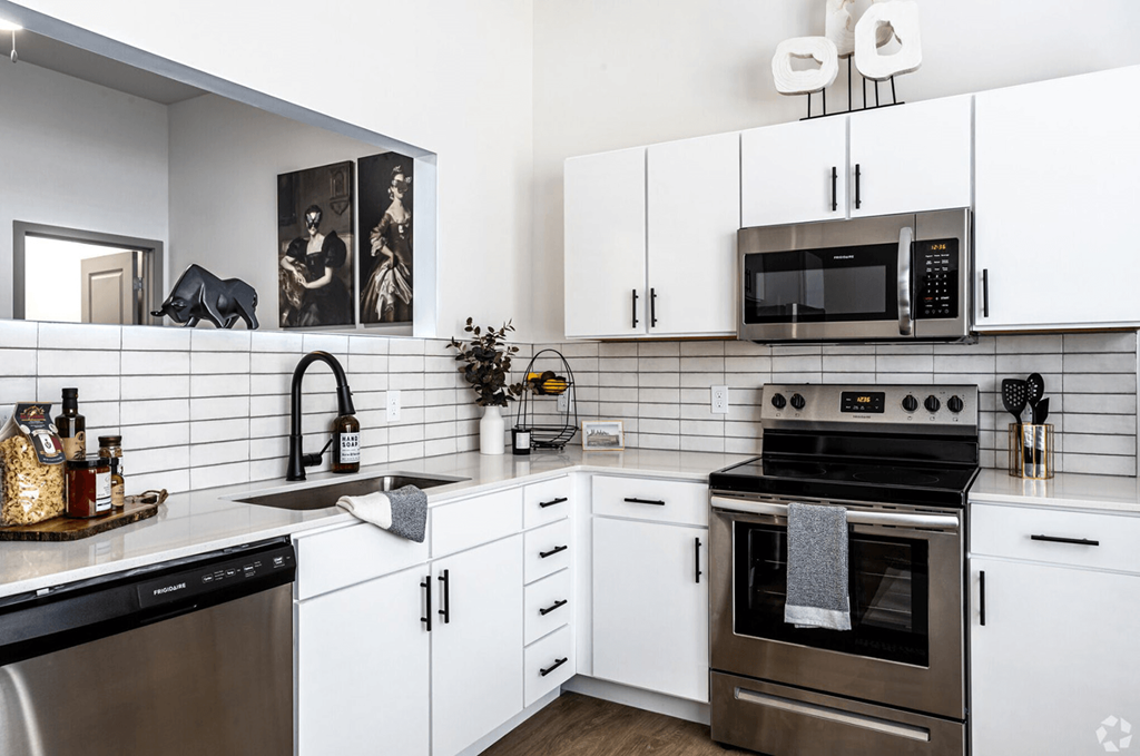 A modern kitchen with white cabinets and a black stove top. A modern kitchen with white cabinets and a black stove top.at Converge KC Uptown, Kansas City, 64111