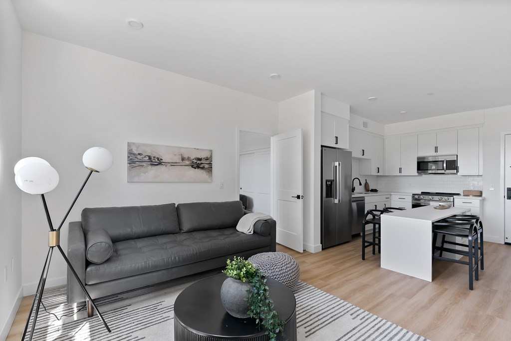 A modern living room with a grey sofa and a black coffee table.