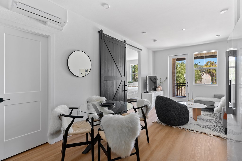 A modern dining room with a glass table and chairs.