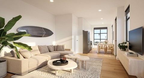 A modern living room with a large couch, a coffee table, and a flat-screen TV.