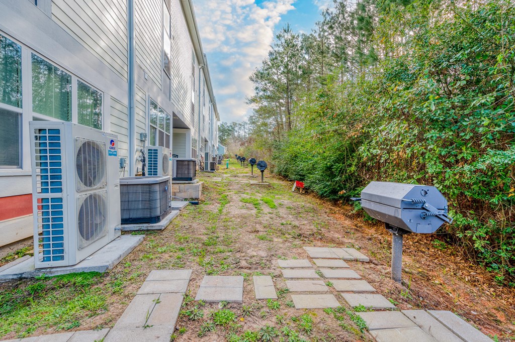 two people walking down a path next to a house with a mailbox