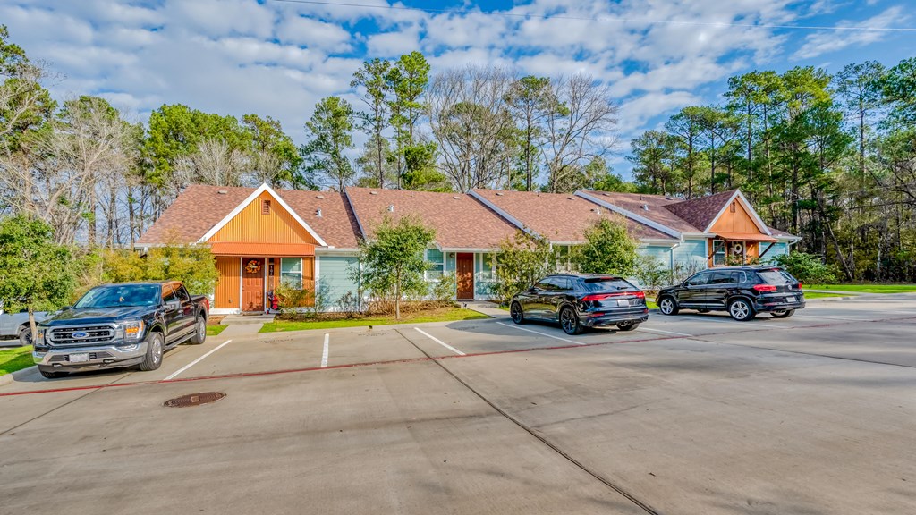 a house with a parking lot and cars in front of it