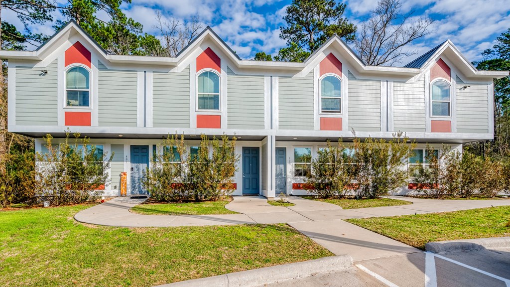 a blue house with red and white siding and a sidewalk