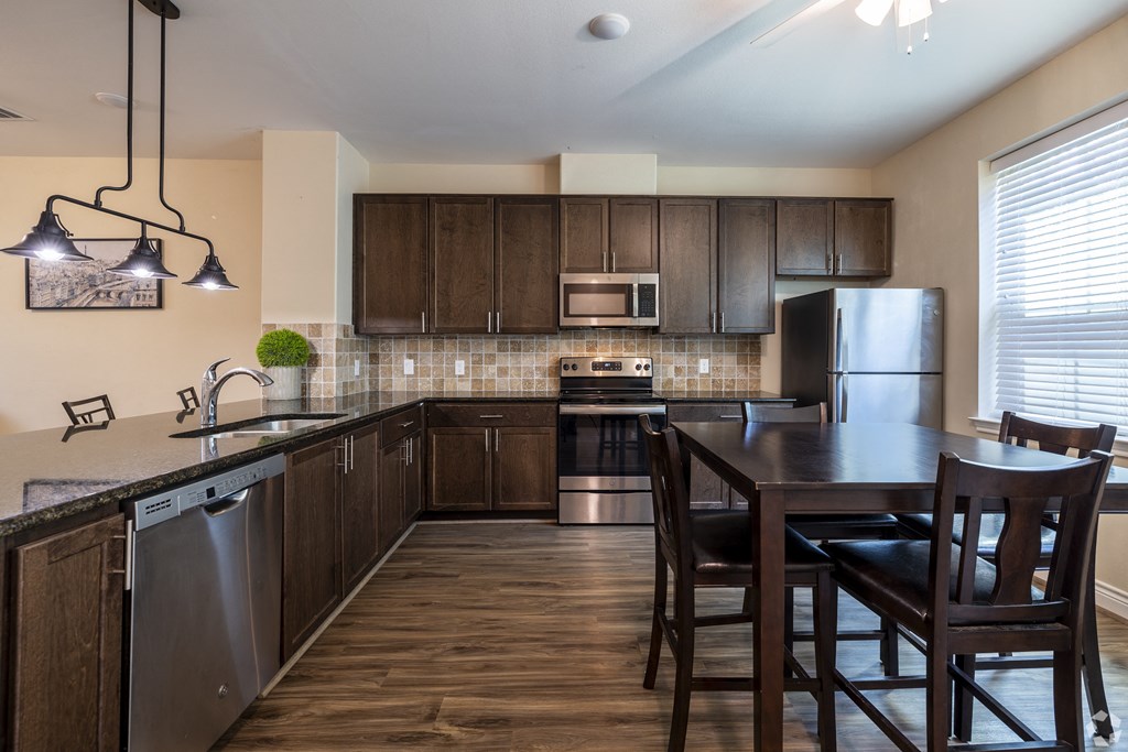 a kitchen with a island and a table with chairs