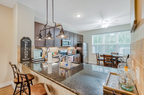 the kitchen and dining area of a home with a granite counter top