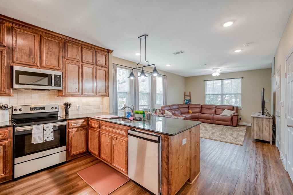 an open kitchen and living room with wood cabinets
