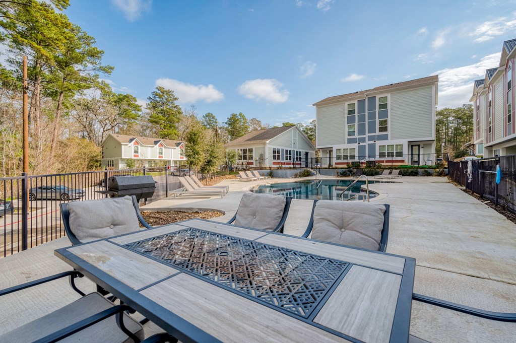 a patio with a table and chairs and a pool