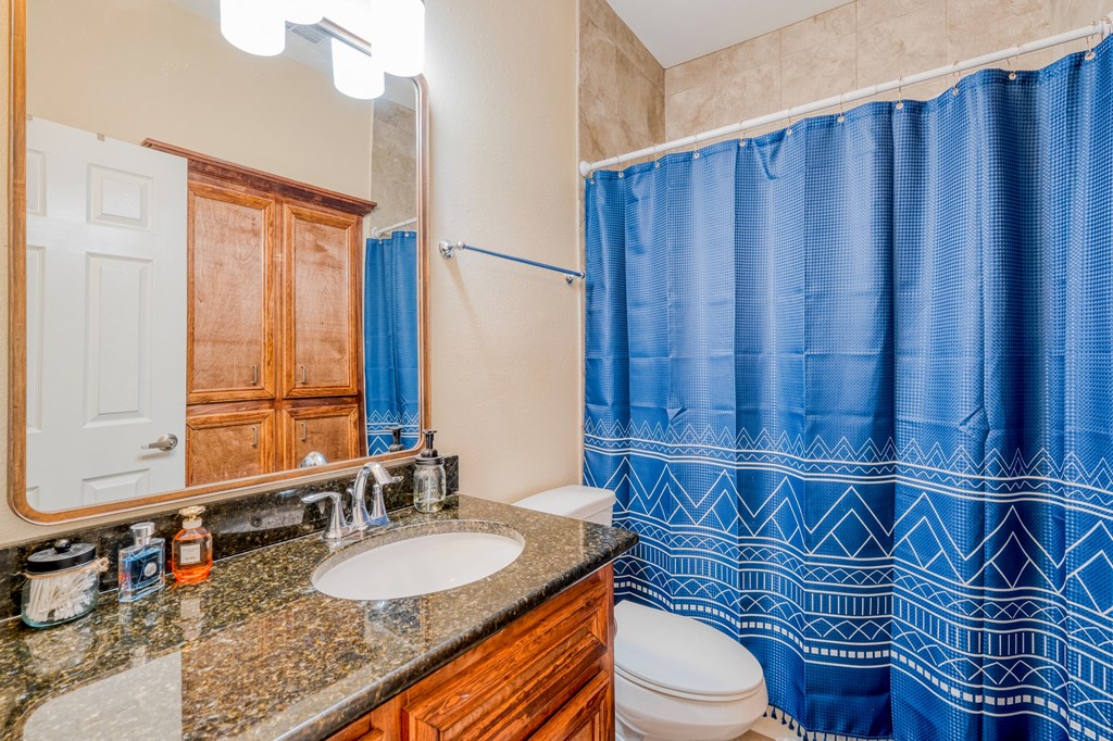 a bathroom with a blue shower curtain and a sink