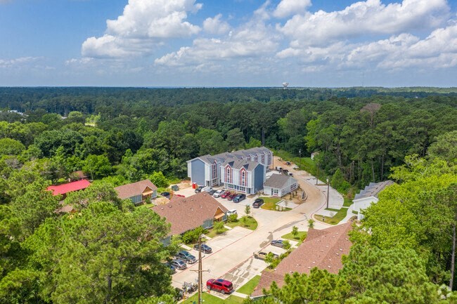 a view of a building from above with trees and a parking lot