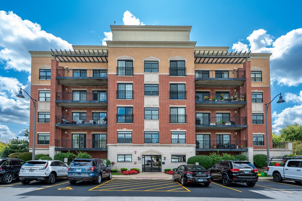 A large red brick building with a parking lot in front.