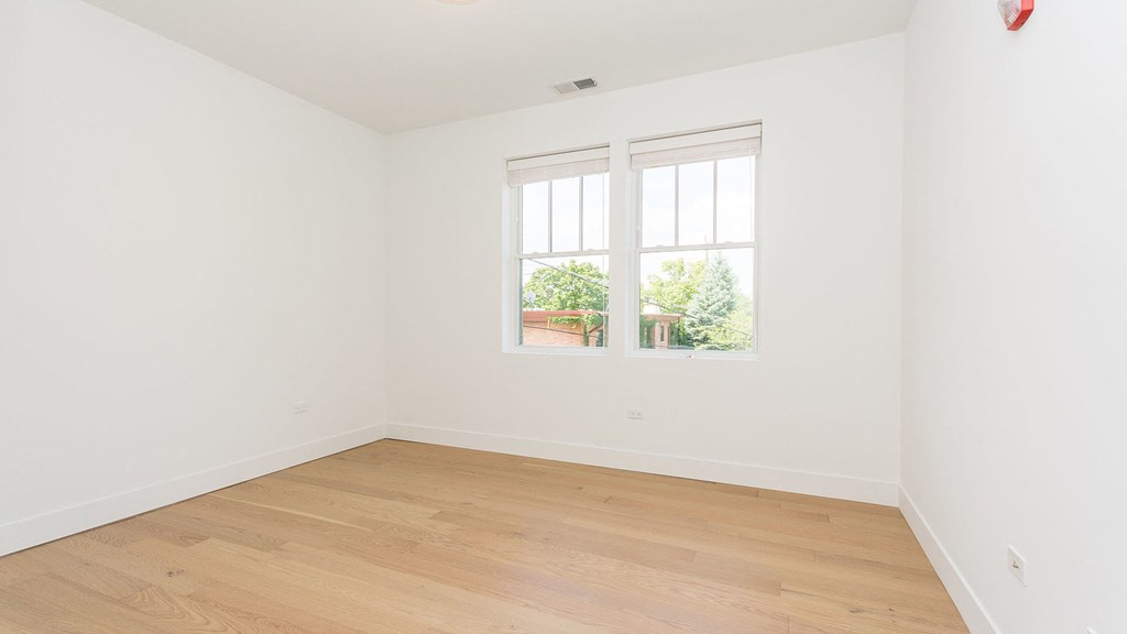 a room with white walls and a window and wooden floors