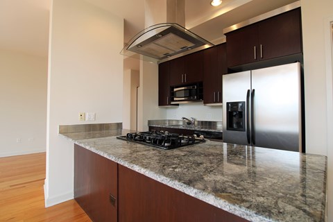 A kitchen with a stove top oven and a refrigerator.