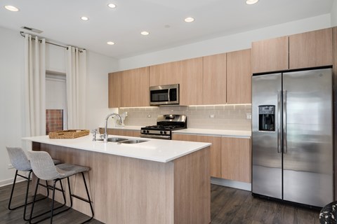A modern kitchen with a white countertop and stainless steel appliances.