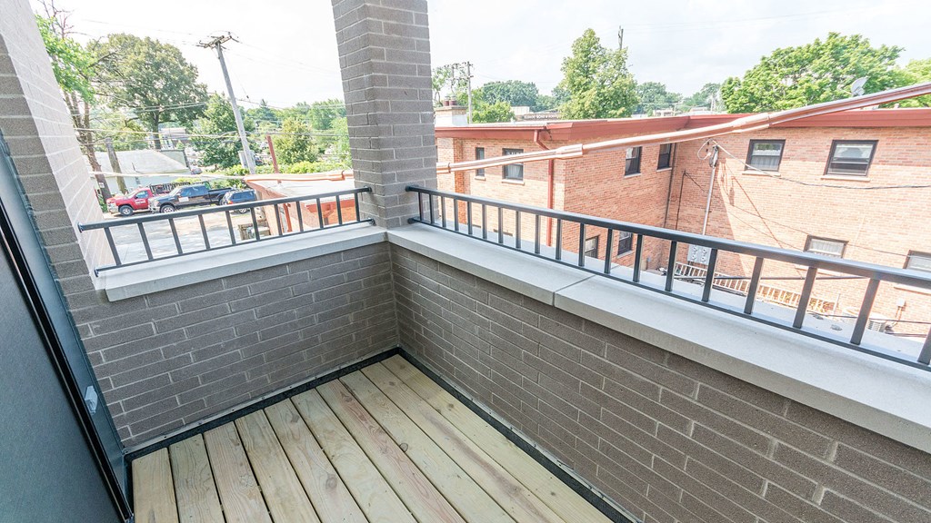 a balcony with a brick wall and a wooden floor