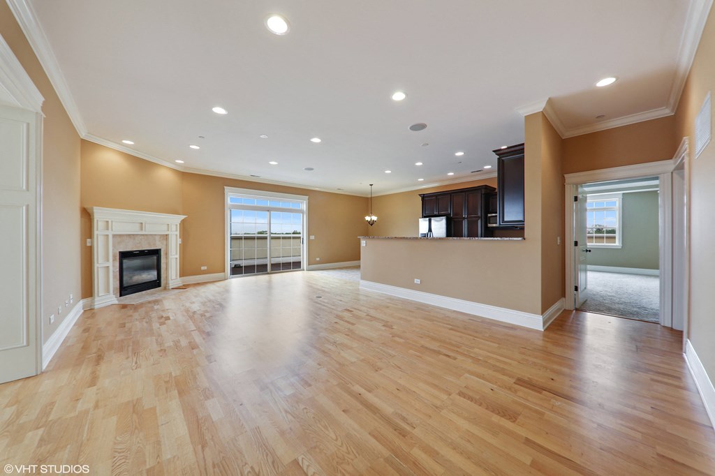 an empty living room with a fireplace and hardwood floors